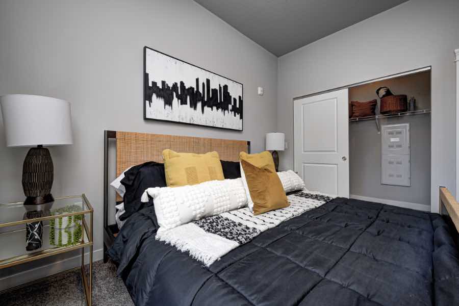 Master bedroom with bed, wall art, and nightstand in apartment